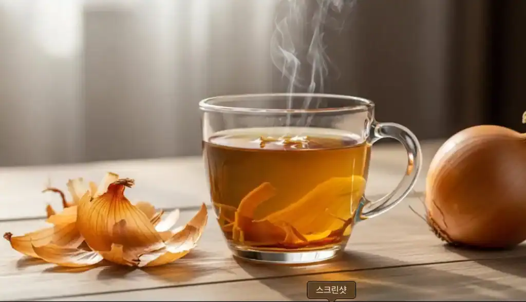 따뜻한 양파 껍질 차 양파의 효능- 아늑한 분위기의 나무 테이블 위, 투명한 유리잔에 담긴 황금빛 갈색의 따뜻한 양파 껍질 차. 김이 모락모락 피어오르고 있다.